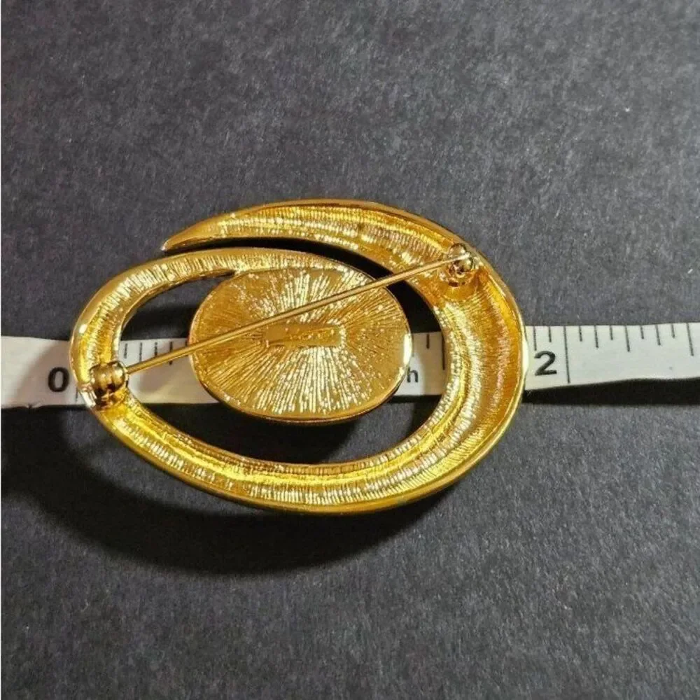 Vintage Monet gold tone swirl brooch